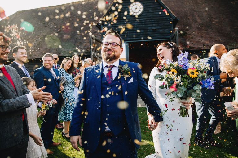 walking out of the lains barn black doors into a sea of confetti and loving friends and family