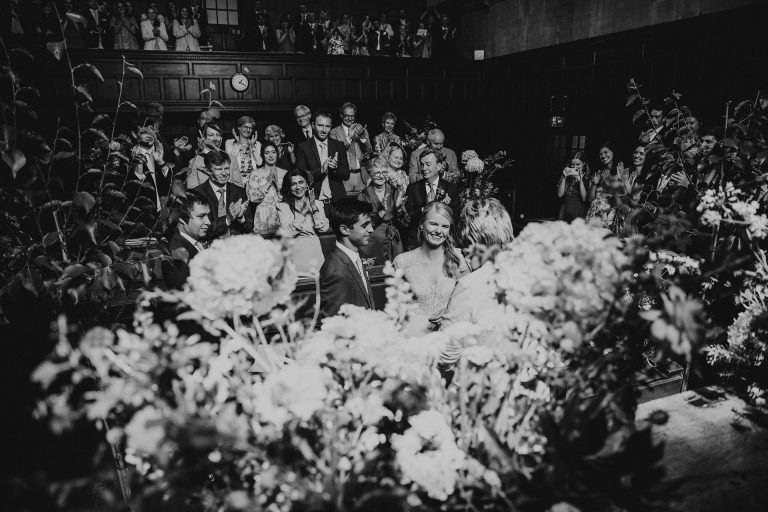 Couple in a sea of flowers in the courtroom of Oxford town hall